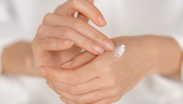 Auftragen einer pflegenden Handcreme auf die Haut