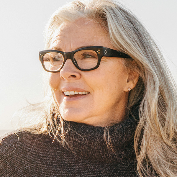 Eine Frau mit Brille genießt die Sonne.