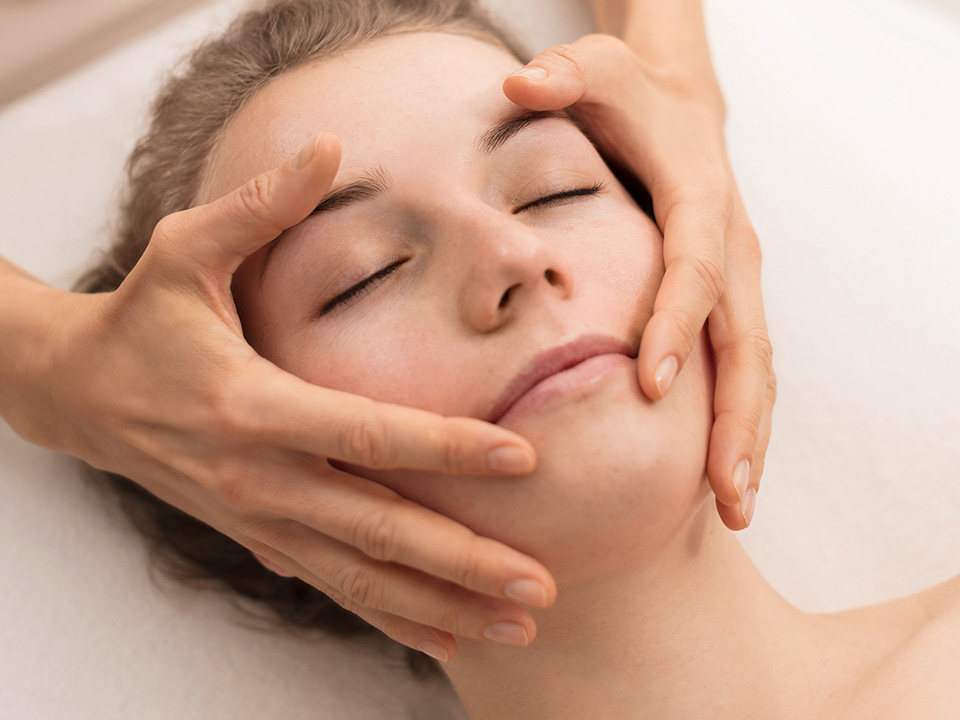 Eine Frau erhält eine entspannende Gesichtsbehandlung in einem ruhigen Spa-Umfeld.