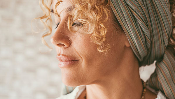 Gelassen lächelnde Frau mit natürlicher, gepflegter Haut