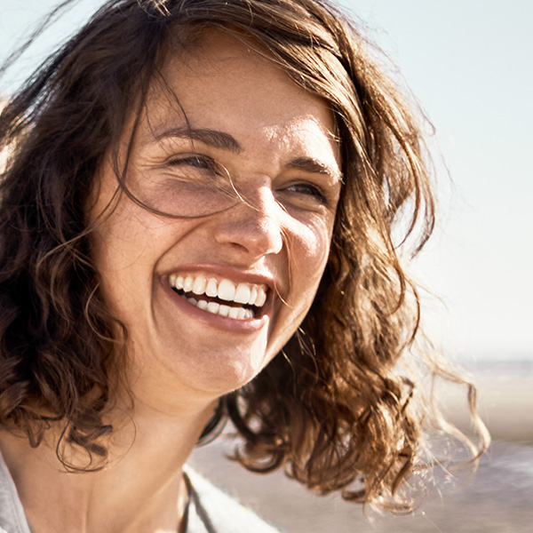 Frau genießt lachend die Sonne