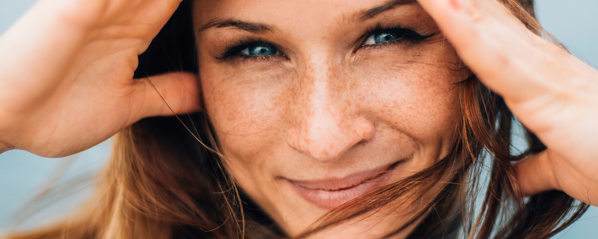 Close-Up einer lächelnden Frau im Wind